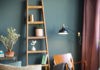 zielona ściana, drewniany regał, kolorowe poduszki